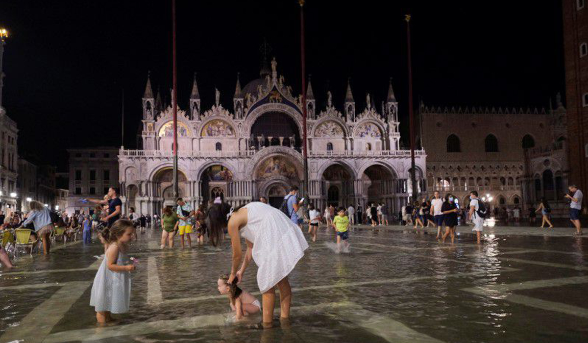 Tourists wade through Venice square hit by unseasonal flood